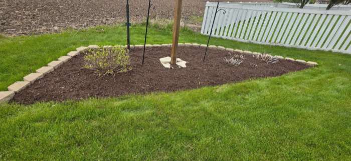 The same stone-bordered bed finished with even, fresh mulch